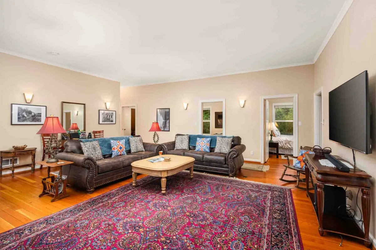 A cozy lounge area with sofas, a coffee table, rug, wall decor, and a television. While primarily a space for relaxation and socializing, the coffee table suggests it can double as a spot for board games or puzzles. The decor is inviting and encourages gatherings and group entertainment.