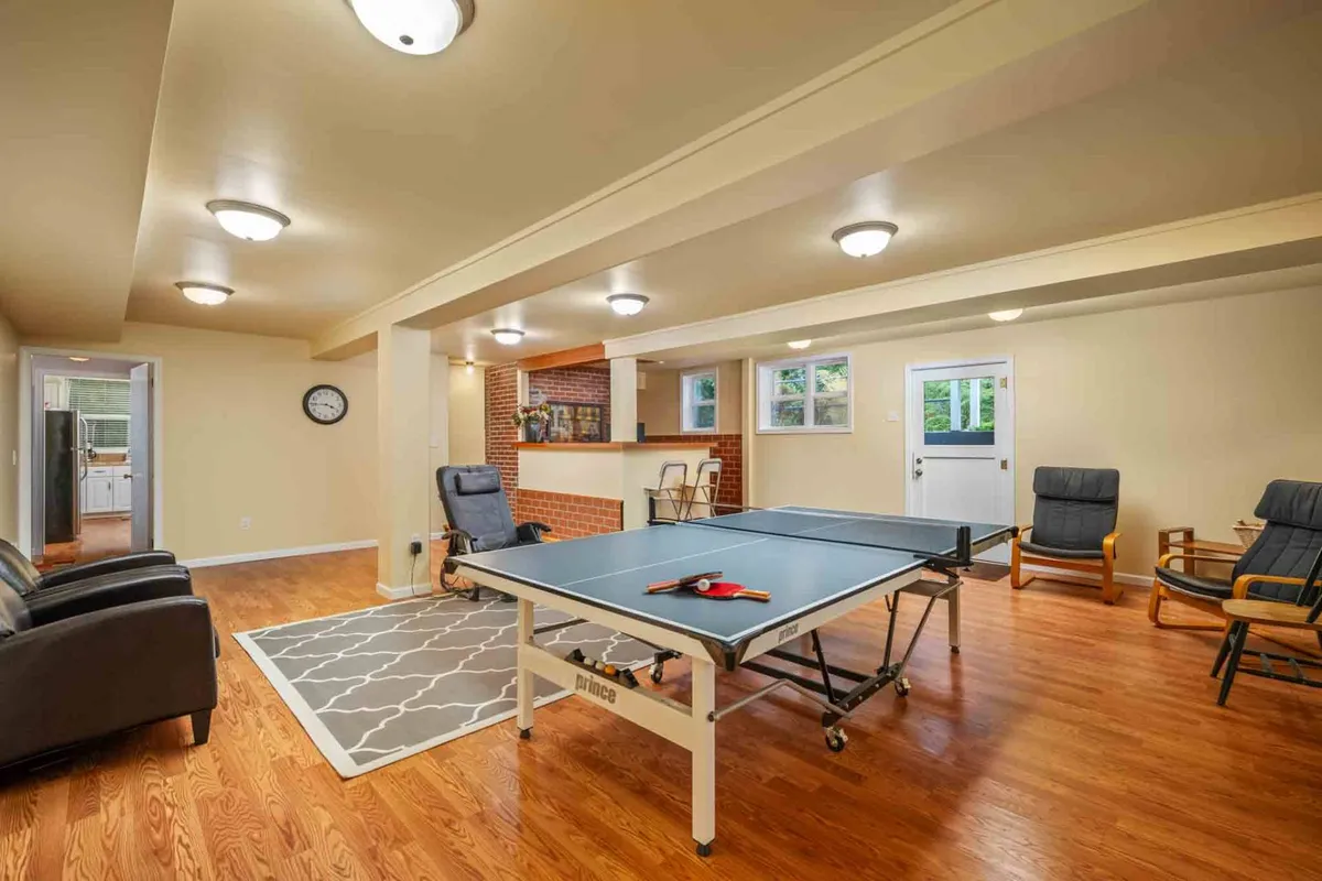 A playful interior space with a ping pong table, comfortable seating area, and a bar counter set against a backdrop that encourages socializing. The mood is lighthearted, ideal for game nights and making memories together.